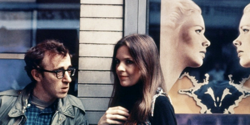 伍迪·艾伦（左）执导影片<em>《安妮·霍尔》</em>的剧照，背景中是英格玛·伯格曼影片<em>《面对面》</em>的海报